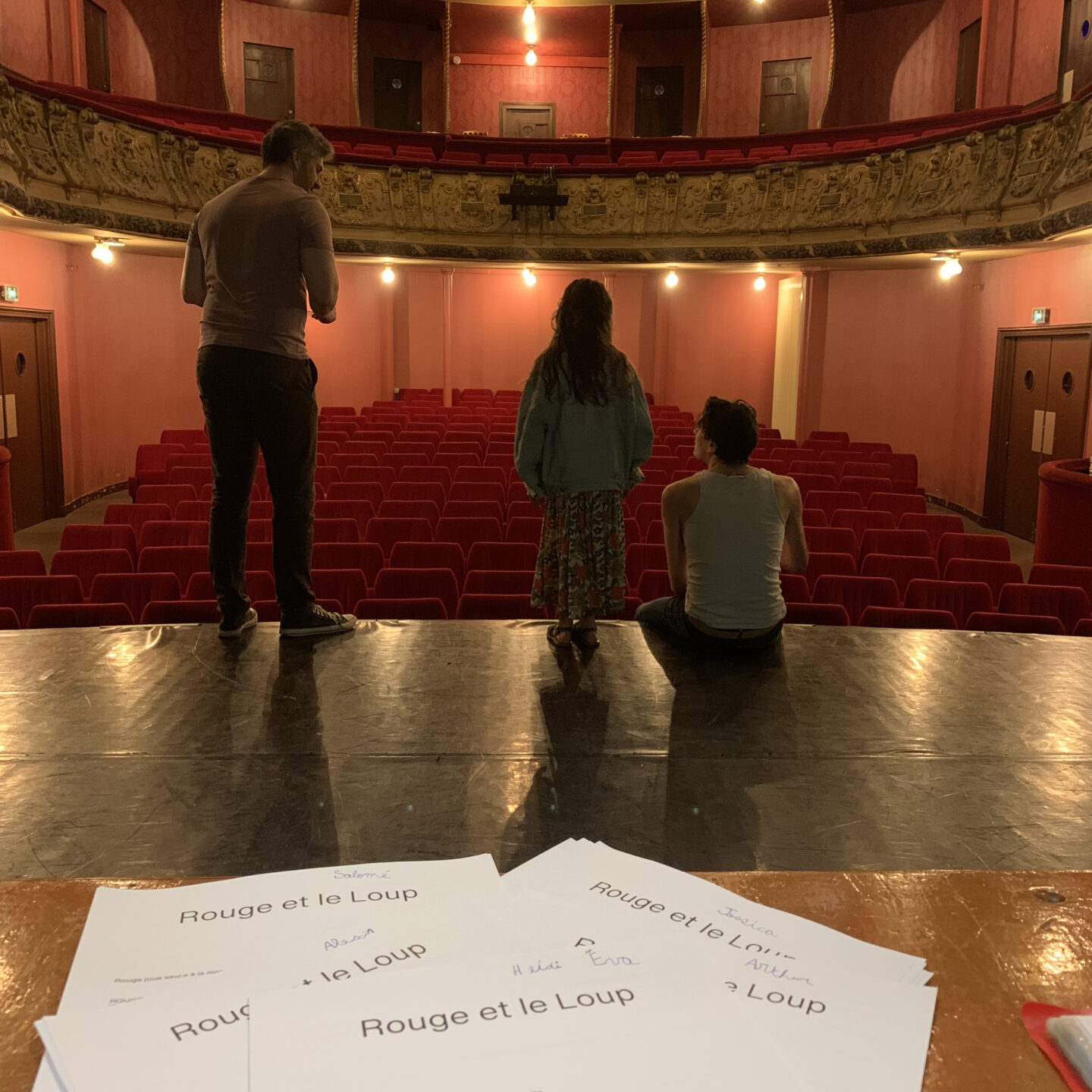 comédiens de dos regardant des sièges de théâtre