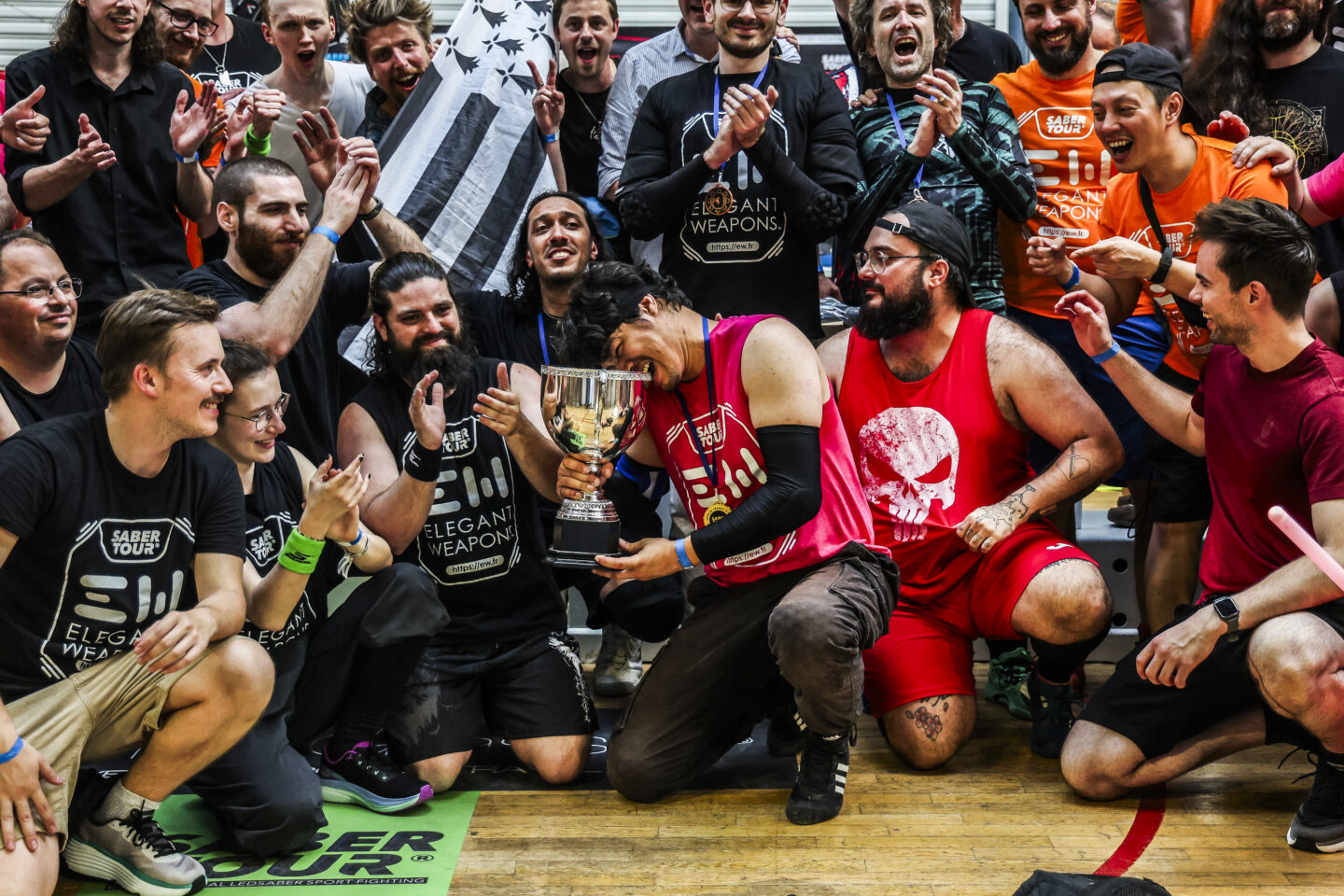 Le champion 2025 croque son trophée, entouré d'une foule de compétiteurs en liesse lors de la remise des prix de l'Open de France 2025.